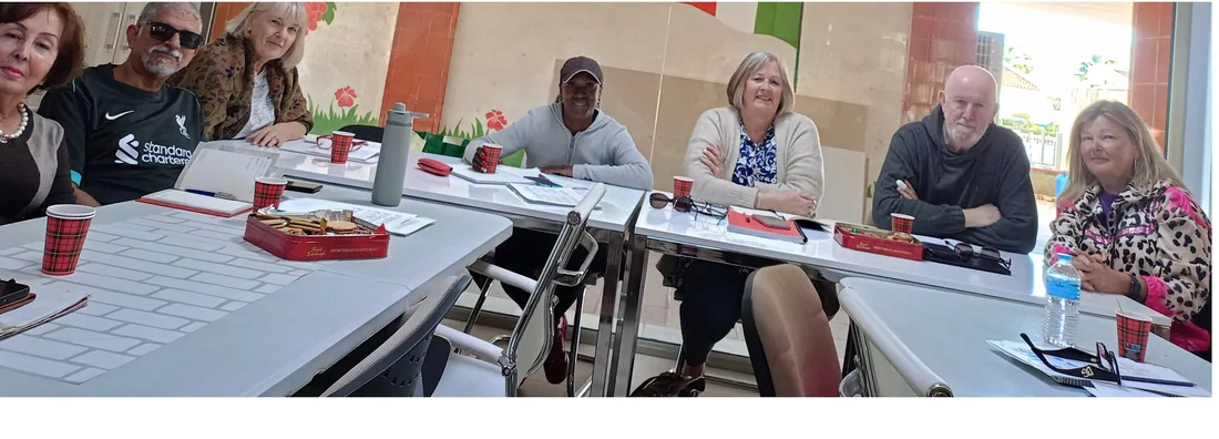 Des élèves le long de la grande table de la salle